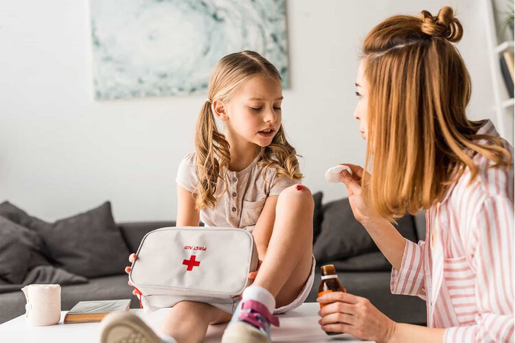 mom putting bandage on child